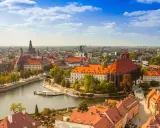 Widok na Ostrów Tumski we Wrocławiu, idealne miejsce na city break z Wrocławia. Rzeka, zabytkowe budynki i błękitne niebo.