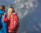 Para jedzie w góry, zastanawiając się, jaki plecak w góry na jeden dzień będzie najlepszy. Ona ma czerwony, on niebieski.