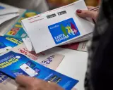 Karta Seniora Carrefour daje zniżki i rabaty. Na zdjęciu widać ulotki i kartę z logo Carrefour.