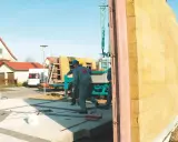Budowa domu z keramzytu. Pracownicy montują prefabrykowane ściany.