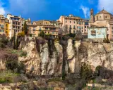Häuser klammern sich an steile Felsen in Cuenca, Spanien. Eine Kathedrale thront über der Stadt.