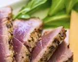Saftiges Thunfischfilet, perfekt angebraten, mit Gewürzkruste, serviert mit frischem Grün und Honigmelone.