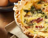 Une délicieuse tarte aux épinards et lardons, dorée et appétissante, prête à être dégustée.
