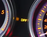 Żółta kontrolka DPF świeci się na desce rozdzielczej, sygnalizując potencjalne problemy z filtrem cząstek stałych.
