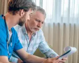 Lekarz omawia z pacjentem wyniki badań. Czy biopsja prostaty boli? Pacjent z niepokojem słucha wyjaśnień.
