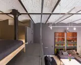 Nowoczesna antresola w pokoju dziecka z łóżkiem i widokiem na salon z sofą.