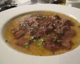 Ein Teller mit Tafelspitz, zartes Rindfleisch in Brühe, garniert mit frischen Kräutern. Ein Klassiker des Tafelspitz Rezepts.