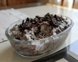 Pyszne lody oreo w szklanej misie, posypane pokruszonymi ciastkami i kakao. Idealne na deser!