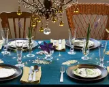 Une table dressée avec élégance, des verres étincelants et des fleurs délicates. L'art de la table est célébré sous un lustre scintillant.