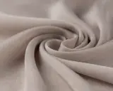A swirl of soft, beige fabric. This close-up shows the texture and drape of a material, making one wonder, is viscose a good material for flowy garments?