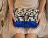 Cartera crochet de colores vibrantes, con un botón cuadrado y un diseño único.