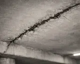 Detalle de grietas en el techo de hormigón, mostrando el acero de refuerzo expuesto. Posibles causas de grietas en el techo.