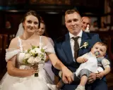Para młoda z dzieckiem na rękach, podwójna uroczystość: ślub i chrzest w jednym.