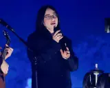 Billie Eilish sjunger på scen i Sverige, med en gitarrist bredvid.