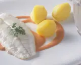 Ein zartes Steinbuttfilet mit Petersilie, serviert mit Salzkartoffeln und einer cremigen Sauce. Der feine Steinbutt Geschmack verspricht ein kulinarisches Erlebnis.