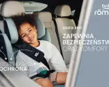 Uśmiechnięte dziecko w foteliku Britax Romer 15-36 Kidfix, zapewniającym maksymalną ochronę i komfort podczas podróży.