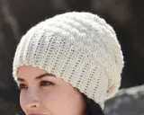 Mujer con gorro de ganchillo blanco con patrón texturizado. ¡Encuentra gorros de ganchillo patrones gratis para crear el tuyo!
