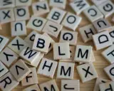 Drewniane klocki z literami, jak w grze Scrabble. Układają się w słowa, może nawet w najdłuższe słowo po angielsku?