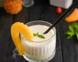 En krämig pina colada med ananasskiva och mynta, redo att avnjutas.