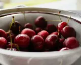 Frisch gewaschene Kirschen in einem Sieb, bereit für das Einkochen ohne Zucker.