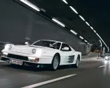 Weißer Ferrari Testarossa fährt durch einen beleuchteten Tunnel.