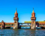 Oberbaumbrücke in Berlin: Ein Muss für jeden Besucher. Eine gelbe U-Bahn fährt über die historische Brücke, die mit ihren Türmchen und Bögen beeindruckt.