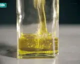 Aceite de oliva vertiéndose en un recipiente de vidrio. La investigación busca determinar cuántas veces se puede usar el aceite de oliva.