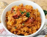 Pyszny bigos z kiszonej kapusty, bogaty w smaku, udekorowany nitkami chili i zieloną cebulką. Idealny na chłodne dni.