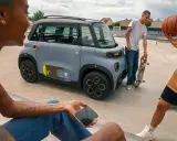 Jóvenes con patineta y balón de baloncesto cerca de un coche gris. ¡Qué ganas de tener el permiso AM que puedo conducir!
