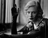 A woman with blonde hair and dramatic earrings smokes, a signature element in many Peter Lindbergh famous photos.