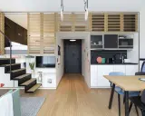 Idée aménagement petit appartement : lit en mezzanine, escalier, cuisine, salle à manger et salon dans un espace optimisé.