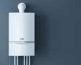 Nowoczesny, biały piec gazowy wiszący na ciemnoszarej ścianie. Idealny wybór, jaki piec gazowy do mieszkania 60m2.