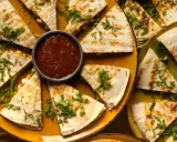 Pyszna quesadilla z mięsem mielonym, pokrojona w trójkąty, podana z salsą i zielonym sosem.
