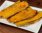 Fette di melanzane fritte, dorate e croccanti, servite su un piatto bianco. Un assaggio delle deliziose melanzane alla pullastiello.
