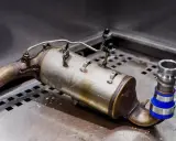Filtr DPF z widocznymi oznakami zużycia, potencjalnie wskazującymi na zapchany dpf objawy. Element układu wydechowego pojazdu.