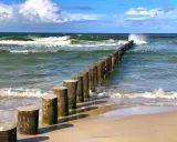 Jastrzębia Góra co zobaczyć: falochrony na plaży i wzburzone morze. Idealne miejsce na spacer i podziwianie Bałtyku.