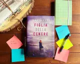 Libro "Figlia della cenere" di Ilaria Tuti, con post-it e agenda. La trama del libro è avvolta da un'atmosfera misteriosa.