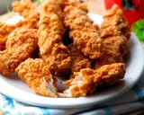 Chrupiące kawałki kurczaka w panierce jak z KFC, z oryginalnym przepisem. Idealne na przekąskę.