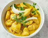 Kyckling i krämig currysås, perfekt för ett snabbt currysås recept. Garnerad med lök och persilja.