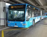 Blå buss 100E vid Budapest flygplats, redo att ta passagerare till centrum.
