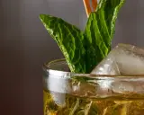 Ein erfrischender Mint Julep mit Eis und Minzblättern, bereit zum Genießen.