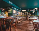 Mysig sydamerikansk restaurang i Stockholm med mörkt gröna väggar, trägolv och dukade bord.
