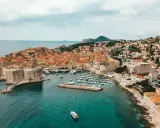 Aerial view of Dubrovnik's historic walled city and harbor, a beautiful destination for a gay vacation.