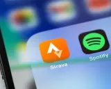 Ikona aplikacji Strava, idealna do śledzenia tras rowerowych, obok Spotify na ekranie smartfona.