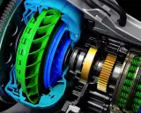 Corte detallado de una **caja de cambios automática** con turbina verde y azul, engranajes dorados y resortes verdes.