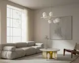 Nowoczesny salon z szarą sofą, okrągłym stolikiem i lampą z kulistymi kloszami w stylu art deco.