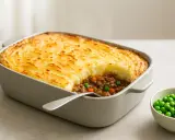 En gyllene gratinerad cottage pie med köttfärs och grönsaker, redo att serveras. Ett perfekt recept för en mysig middag.