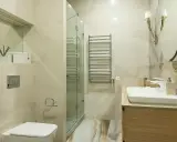 Baño moderno con ducha de cristal, lavabo y WC. Ideal para instalar extractor baño y mantener el ambiente fresco.