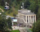 Kolejka linowa nad budynkiem stacji PKL na Kasprowym Wierchu, z widocznymi samochodami i ludźmi.