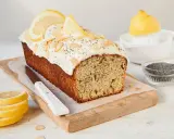 Saftiger zitronenkuchen mit mohn, garniert mit Mandelsplittern und Zitronenscheiben.